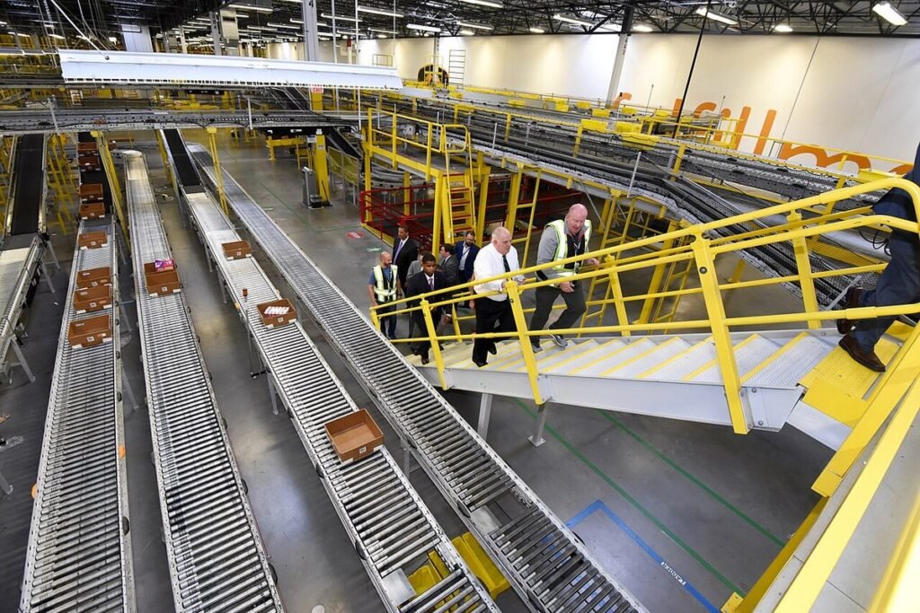 Convoyeurs et passerelles jaunes dans un grand centre de distribution, vus en plongée