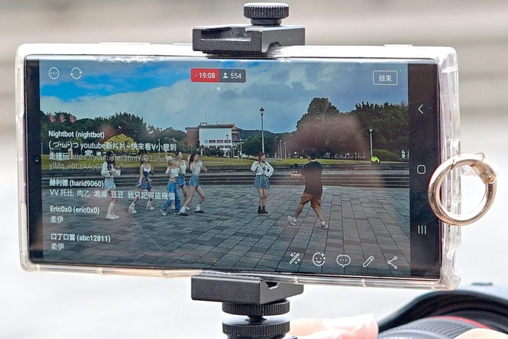 Smartphone monté sur un stabilisateur en train de filmer une scène en extérieur